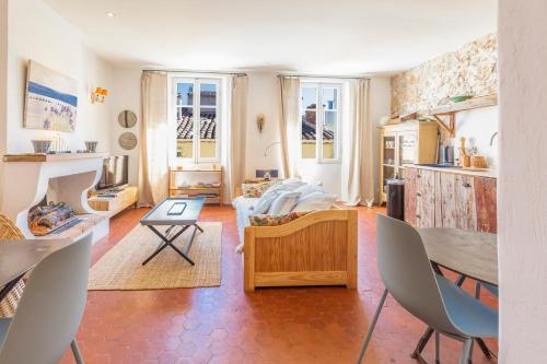 un salon avec un canapé, une table et des chaises dans l'établissement Logement atypique dans la rue Fourmillière, à Antibes