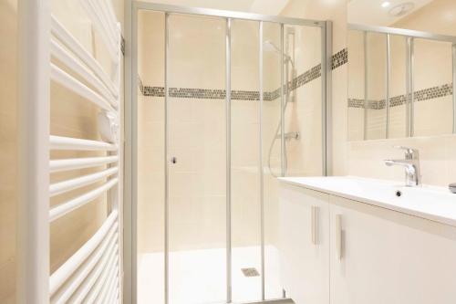 une salle de bain blanche avec une douche et un lavabo dans l'établissement Maison de ville rue Fourmillière, à Antibes