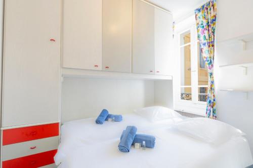 - une chambre avec des armoires blanches et des chaussures bleues sur un lit dans l'établissement Place Amiral Barnaud, à Antibes