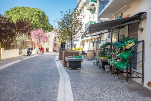 une rue avec un stand de fruits sur le côté d'un bâtiment dans l'établissement Résidence Le Suquet, à Cannes