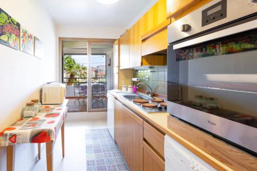 une cuisine avec des armoires en bois et un gros électroménager dans l'établissement Résidence Beauséjour, à Antibes