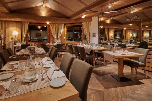 un comedor con mesas y sillas en un restaurante en Hotel Alpenrose Wengen - bringing together tradition and modern comfort en Wengen