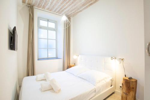 un lit blanc dans une chambre avec une fenêtre dans l'établissement Safranier Villa Emy 201, à Antibes
