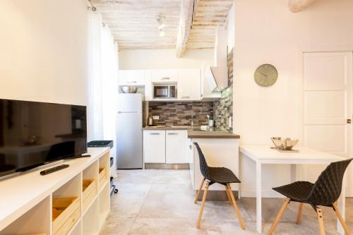 une cuisine avec des armoires blanches et une table et des chaises dans l'établissement Safranier Villa Emy 201, à Antibes