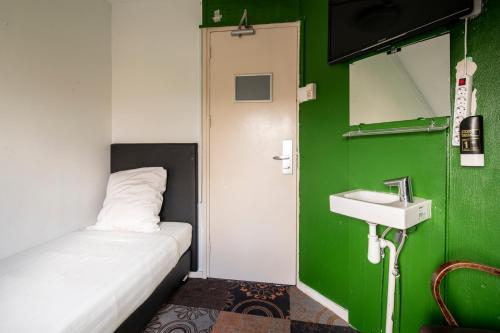 a small room with a bed and a sink at Princess Hostel Leidse Square Amsterdam in Amsterdam