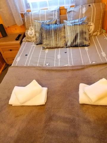 a bed with two pillows on top of it at Pokoje Sowa Domek Sowa in Mikołajki