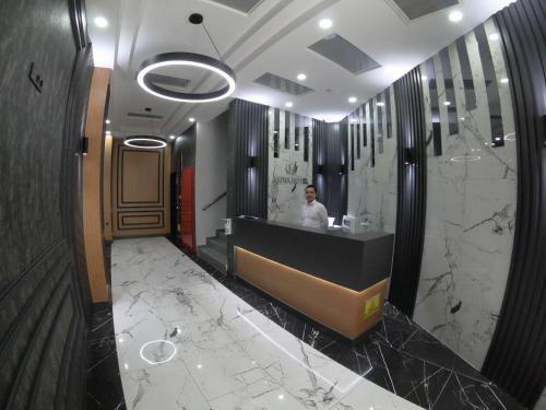 a man standing in a bathroom with a counter at ASİWA HOTEL in Eskisehir