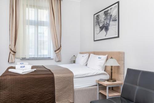 a hotel room with a bed and a chair at Villa Baltic Dream in Międzyzdroje