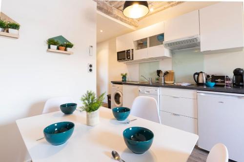 - une cuisine et une salle à manger avec des bols bleus sur une table dans l'établissement Chez Dominique - 1 chbre Centre Antibes Migrainier T2 avec AC, à Antibes