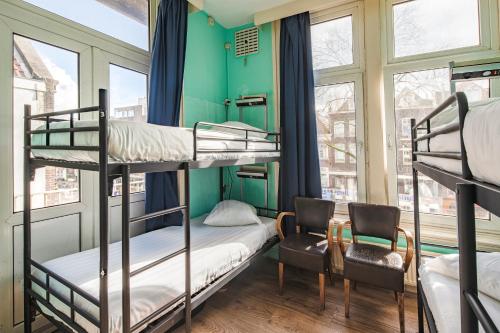 Cette chambre comprend 2 lits superposés et une chaise. dans l'établissement Princess Hostel Leidse Square Amsterdam, à Amsterdam