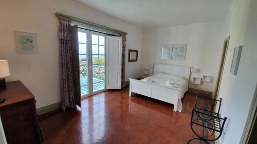 a room with a white bed and a large window at Villa Bouganvilia - Casa da Vigia in Albufeira