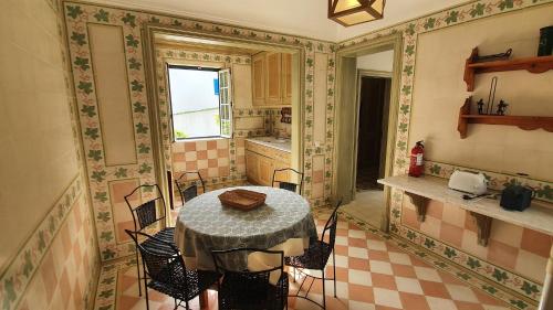 a kitchen with a table and chairs in a room at Villa Bouganvilia - Casa da Vigia in Albufeira