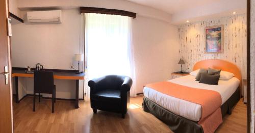 a hotel room with a bed and a desk and a desk at Les Tilleuls Montbeliard Sud Audincourt in Audincourt