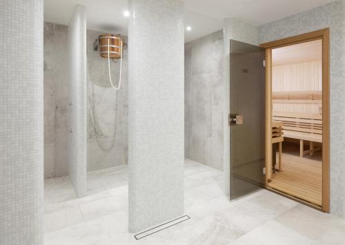 a bathroom with a walk in shower next to a door at Clarion Grandhotel Zlaty Lev in Liberec