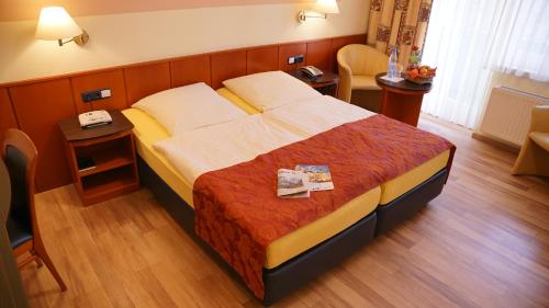 ティメンドルファー・シュトラントにあるAura Hotelのベッドとデスクが備わるホテルルームです。