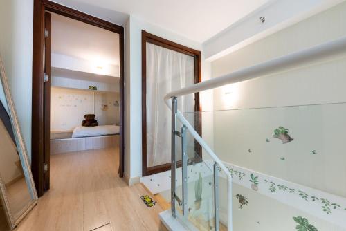 Una escalera que conduce a un dormitorio con un perro en la cama en Yu Jing Xuan Boutique Apartment en Tianjin