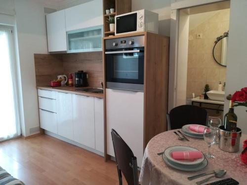 a small kitchen with a table and a microwave at Apartment and room Hudoletnjak in Šilo