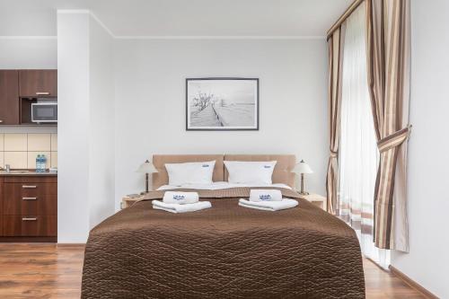 a bedroom with a bed with two towels on it at Villa Baltic Dream in Międzyzdroje