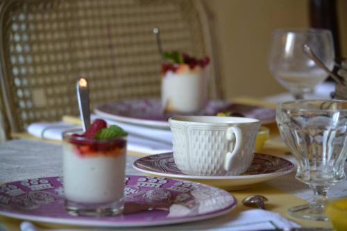 una mesa con tres tazas y platos de comida en " Chimay B & B " - ptits déj gourmands proposés, en Chimay