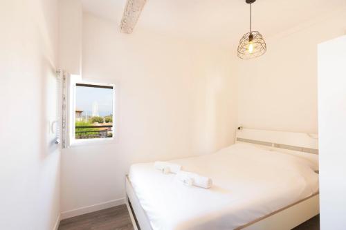 une chambre blanche avec un lit et une fenêtre dans l'établissement Chez Dominique - 1 chbre Centre Antibes Migrainier T2 avec AC, à Antibes