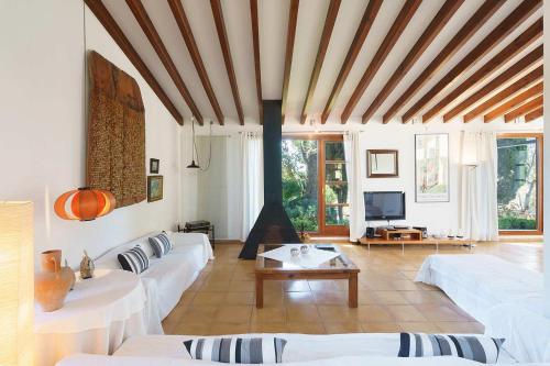 a living room with white couches and a tv at Villa Can Canaver in Pollença