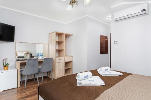 a room with a bed and a desk and a kitchen at Villa Baltic Dream in Międzyzdroje