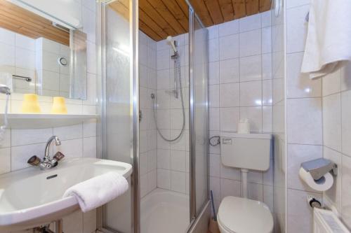 a bathroom with a shower and a sink and a toilet at Pension Sonneck in Lofer