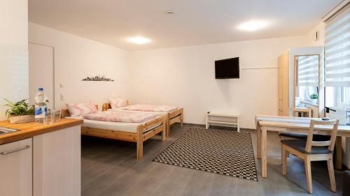 een kamer met een bed, een bureau en een tafel bij Apartment Liß in Gladbeck