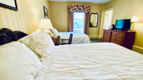 a hotel room with two beds and a television at Shawnee Inn and Golf Resort in East Stroudsburg