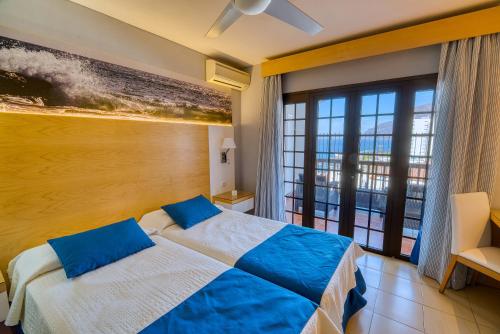 a bedroom with a bed and a large window at Ona Las Rosas in Puerto de Santiago