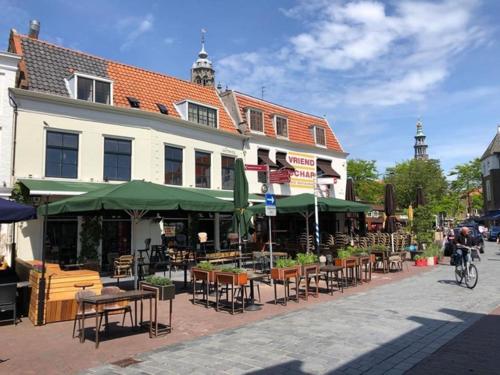a group of tables and chairs in front of a building at Ruime studio 'In de drie koningen' in hartje Middelburg in Middelburg