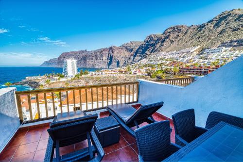 a balcony with chairs and a view of the ocean at Ona Las Rosas in Puerto de Santiago