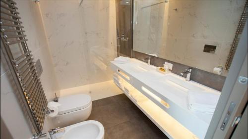 a bathroom with a toilet and a sink and a mirror at Hotel Principe Palace in Lido di Jesolo