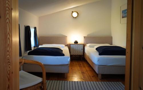 NeddesitzにあるJasmundhusのベッド2台、壁掛け時計付きの客室です。