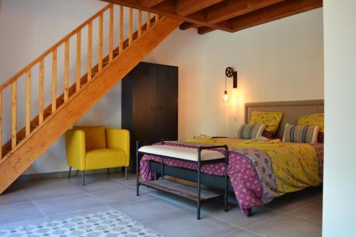 1 dormitorio con 1 cama y 1 silla amarilla en La Romagnolette, en Saint-Restitut