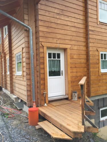 eine Veranda eines Hauses mit weißer Tür in der Unterkunft Ferienwohnung Grünebach in Grünebach
