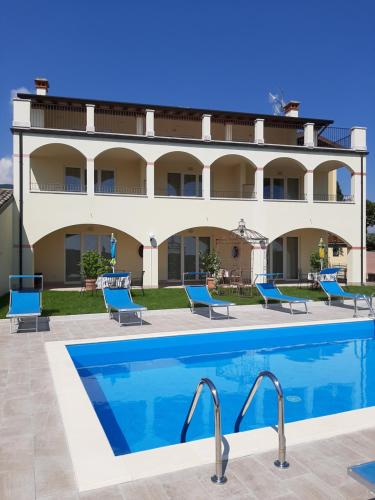 um hotel com piscina em frente a um edifício em Villa Benvenuto em Costermano