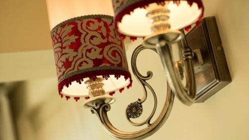 a lamp with a red and white shade on a wall at Relais Colle San Pietro in Verona