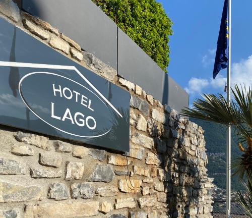 a sign for a hotel lago on a stone wall at Hotel Lago in Torno