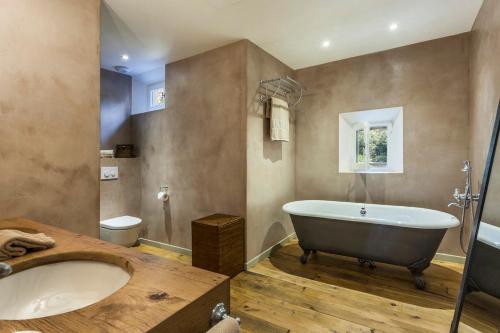 a large bathroom with a tub and a toilet at Domaine Les Mésanges in Saint-Tropez