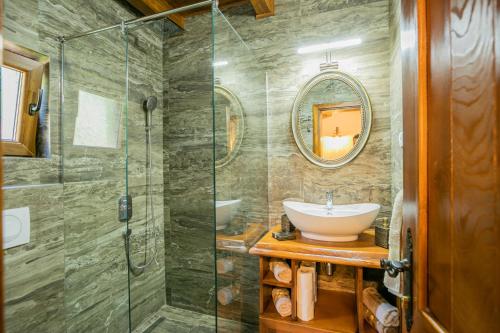 a bathroom with a sink and a glass shower at Ethno Lodge AB in Virpazar