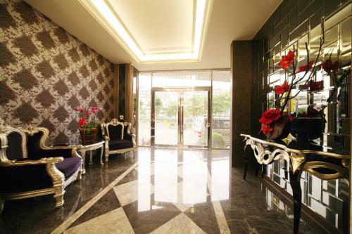 a lobby with two chairs and a door with flowers at Dubai Villa Motel in Daya