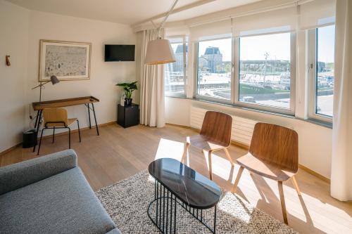 a living room with a couch and chairs and a table at Hotel du Bassin in Ostend