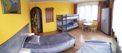 a living room with a bunk bed and a table at Arenda Noclegi Niedzica in Niedzica