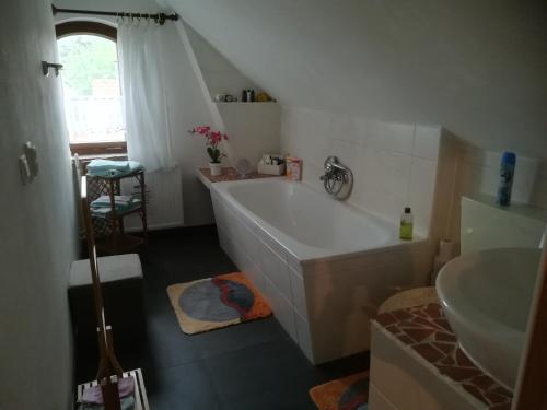 a bathroom with a white tub and a sink at Ferienwohnung Hellriegel in Weißwasser