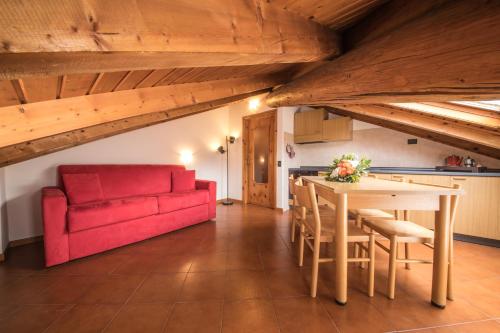 a living room with a table and a red couch at Chalet Felse in Bormio