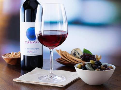 a glass of wine sitting next to a bottle of wine at Hyatt Place Manati in Manati