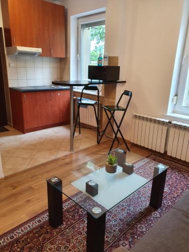 ein Wohnzimmer mit einem Tisch und einer Küche in der Unterkunft Biedronka- samodzielny apartament dla 3 osób z miejscem parkingowym in Sopot