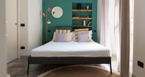 un letto in una camera con parete verde di Charming & Modern flat by Holiday Solutions a Como