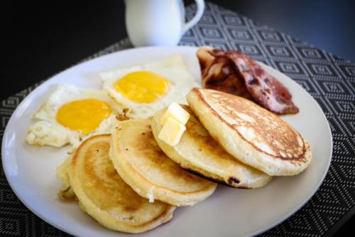 a plate of breakfast food with eggs and bacon at APS Guesthouse in Windhoek